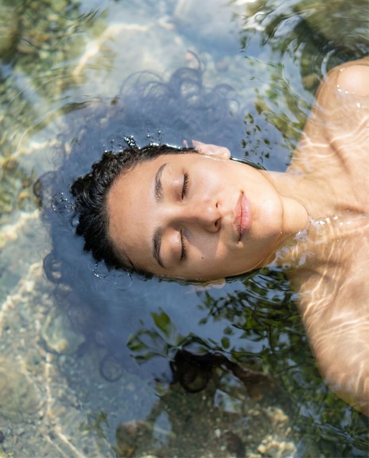 A person floating peacefully in clear natural water